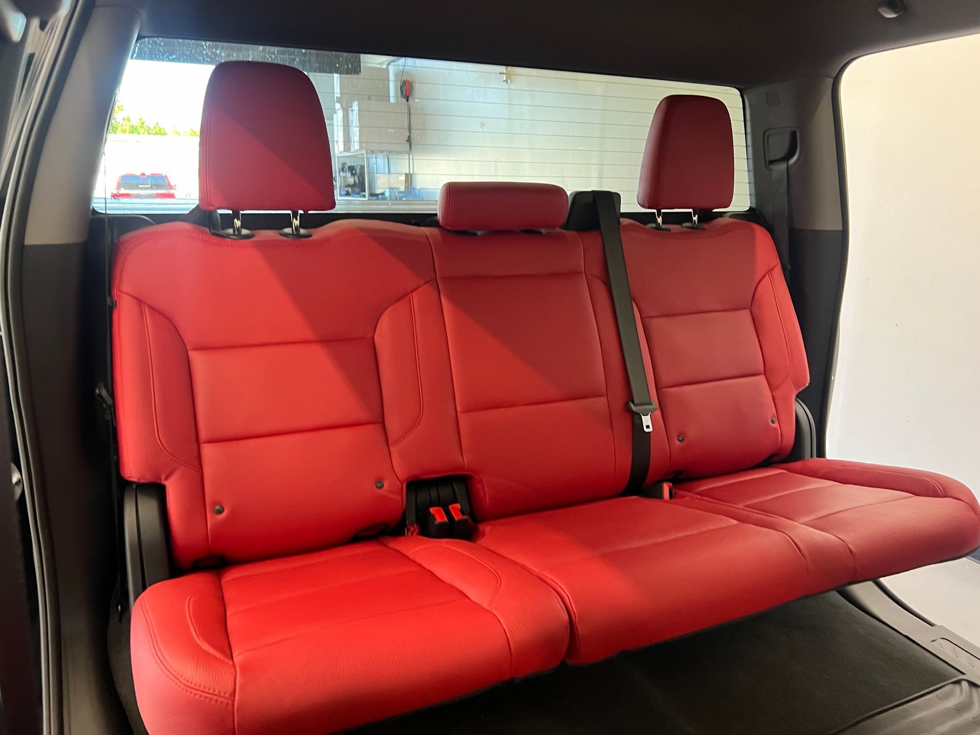the back seat of a truck with red leather seats