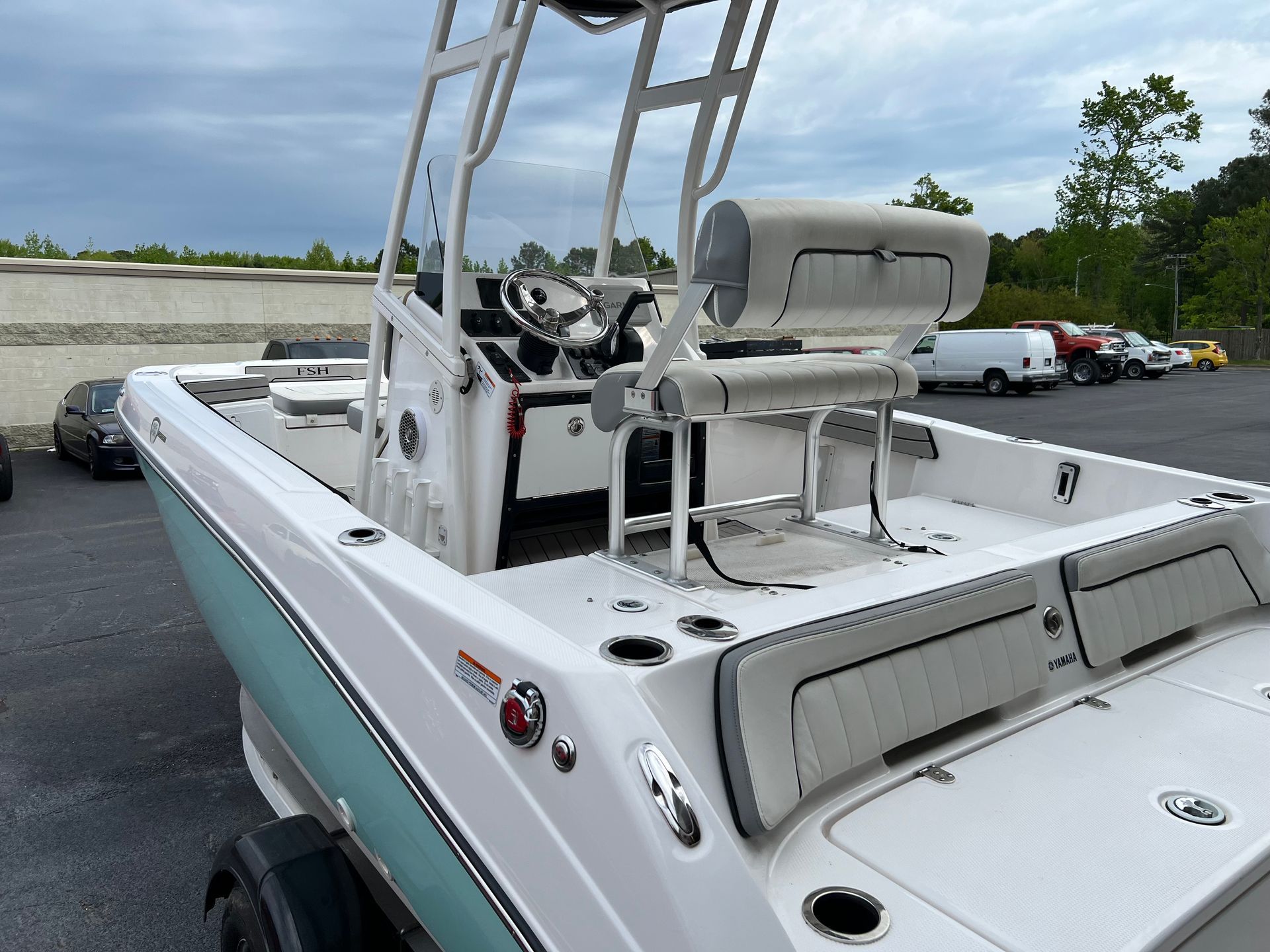 a white boat is parked in a parking lot