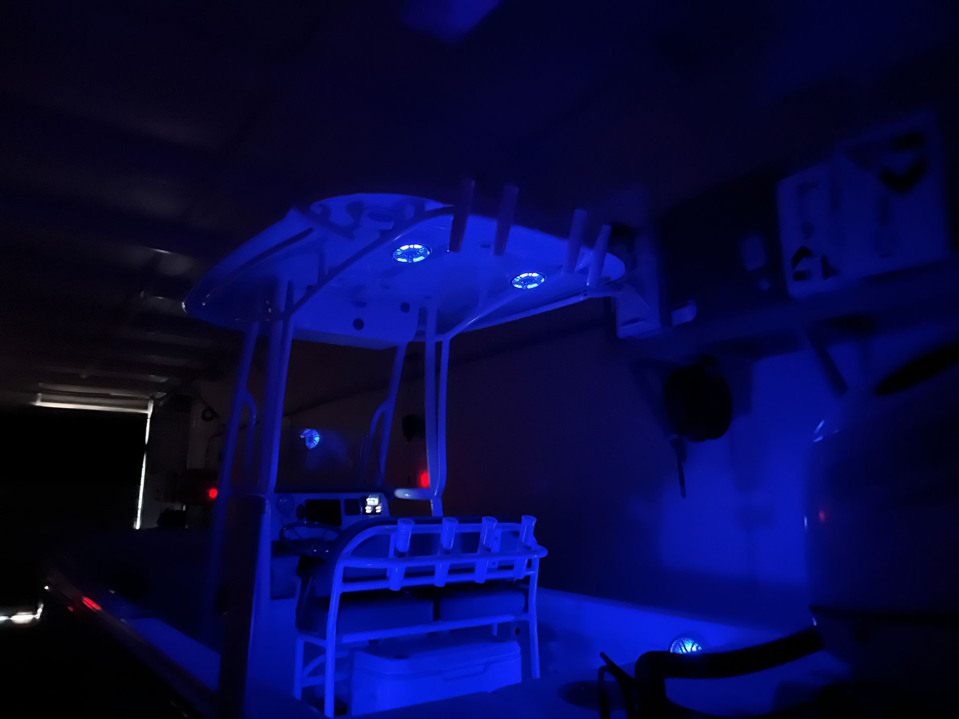 A boat is lit up with blue lights in a dark room