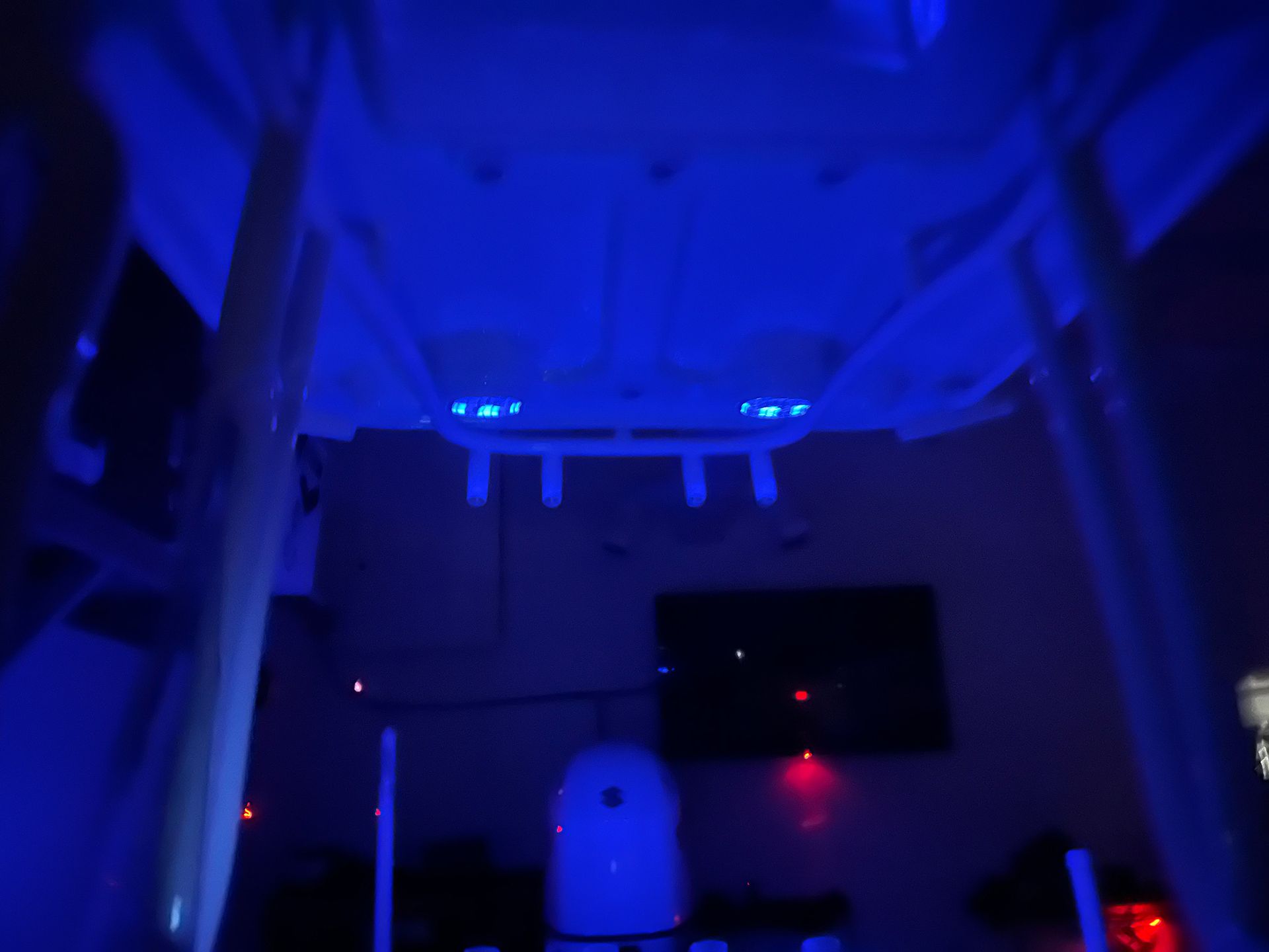 A blue light is shining on the ceiling of a room.