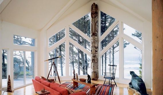 A living room with a red couch and a totem pole
