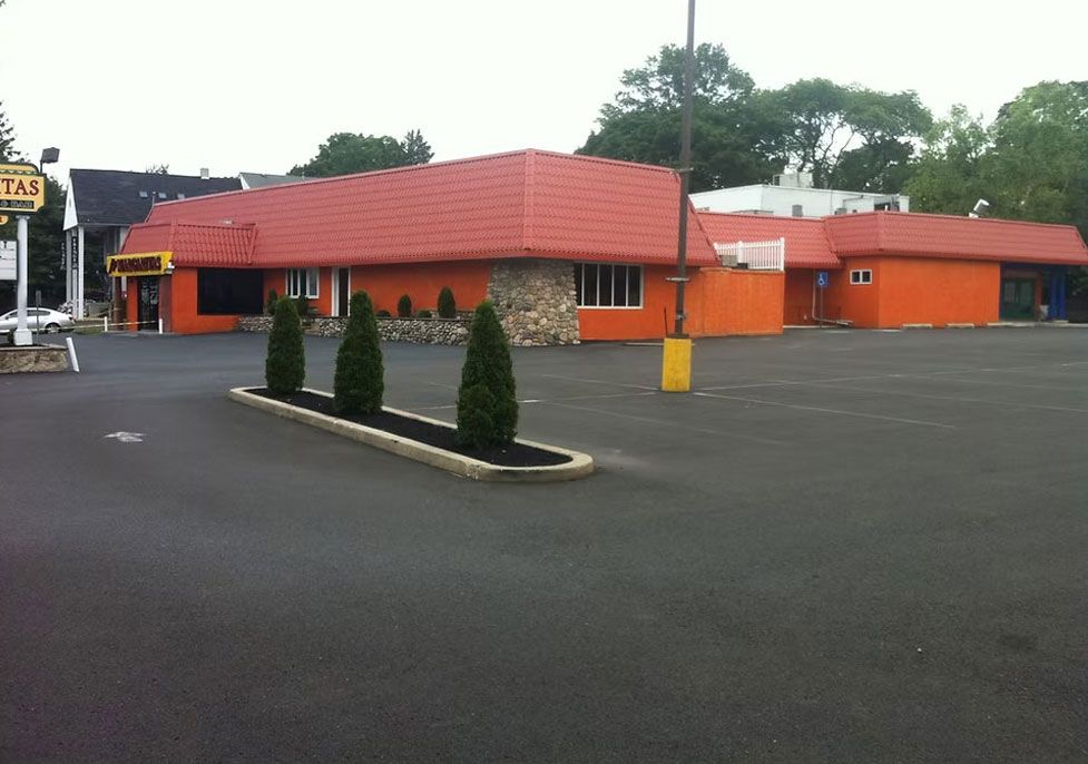 Orange restaurant building with red roof on an empty parking lot - before
