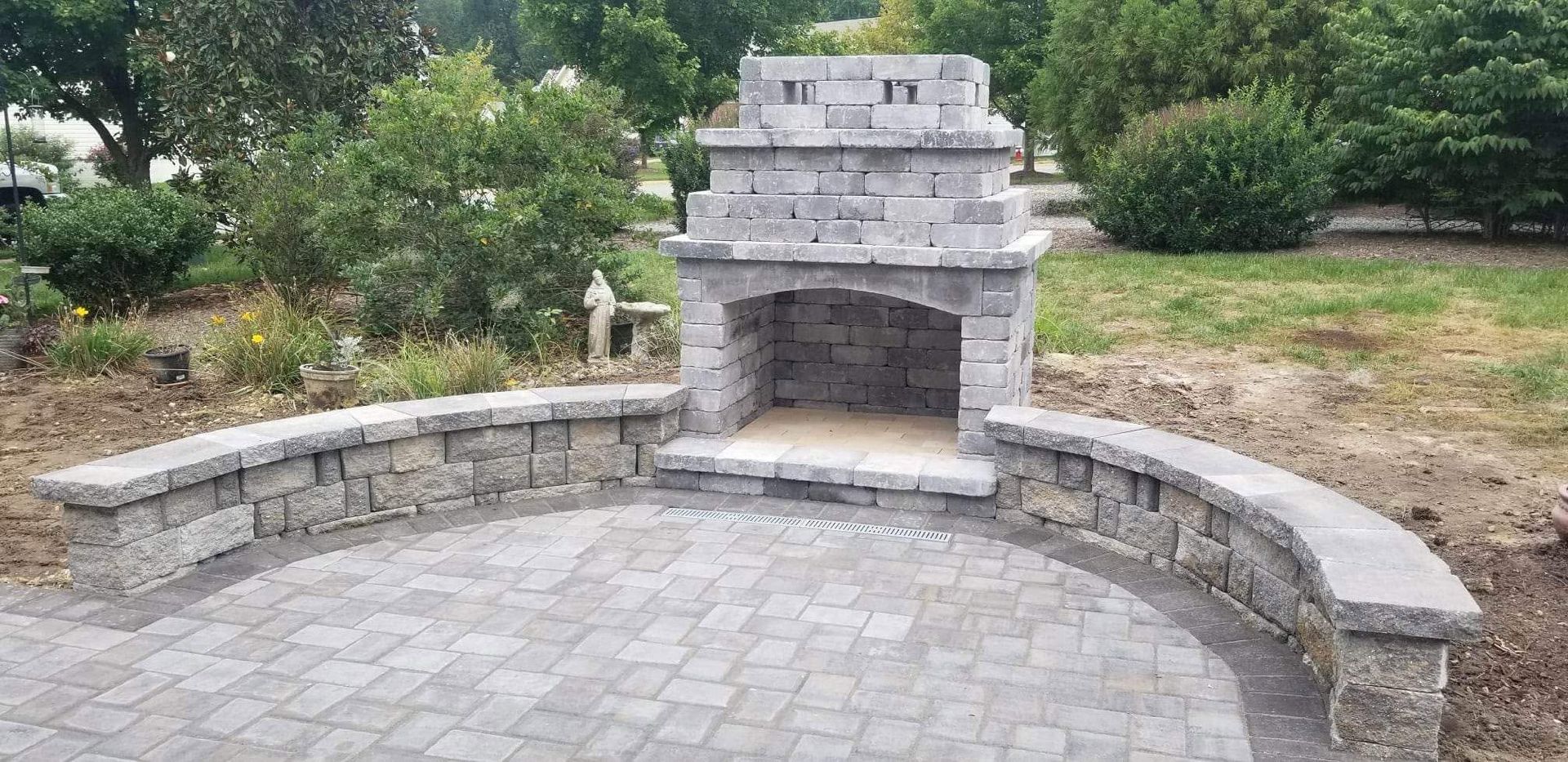 Stone outdoor fireplace with curved bench seating in a park