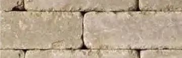 A close-up view of a light-colored, rustic brick wall laid in a standard running bond pattern.
