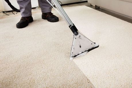Carpet cleaning tool extracting dirt from a beige carpet