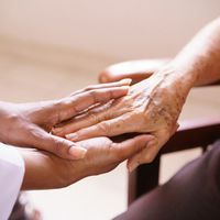A close up of a person holding an older person 's hand.