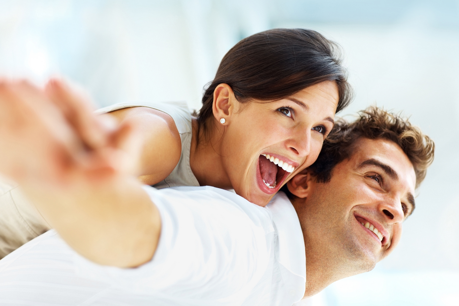 a man is giving a woman a piggyback ride and the woman is laughing