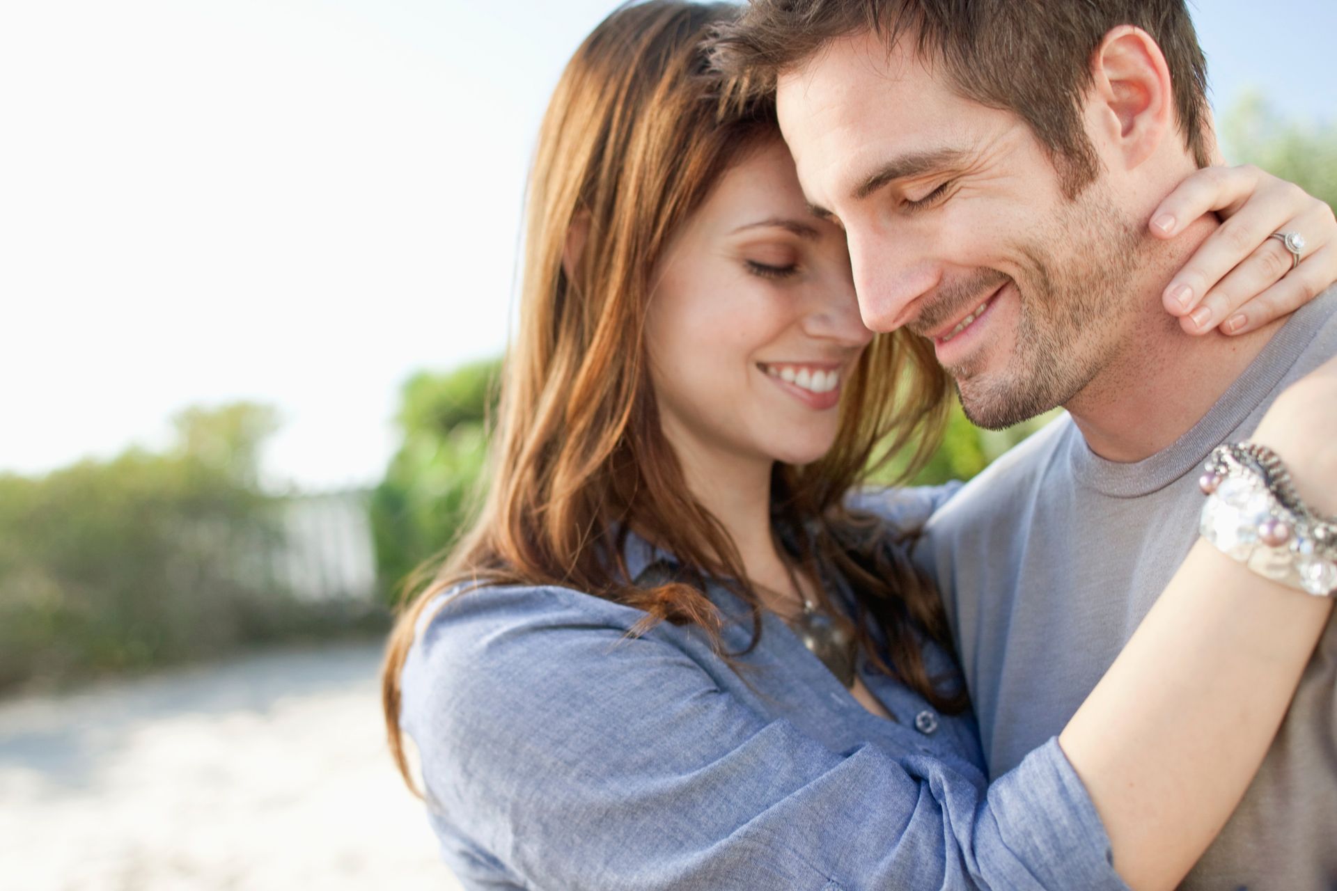 a man and a woman are hugging each other and smiling