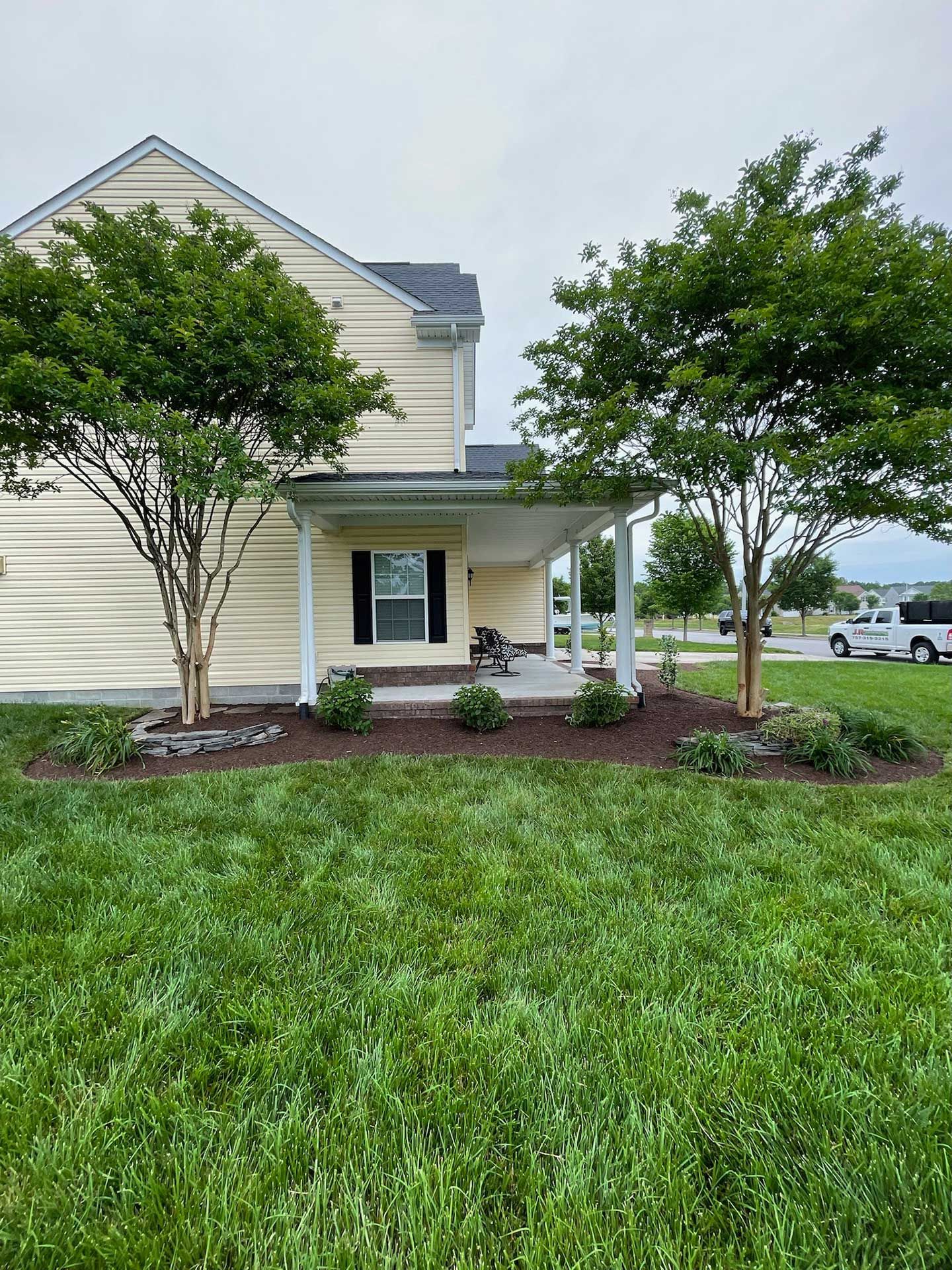 A house with a large lawn and trees in front of it