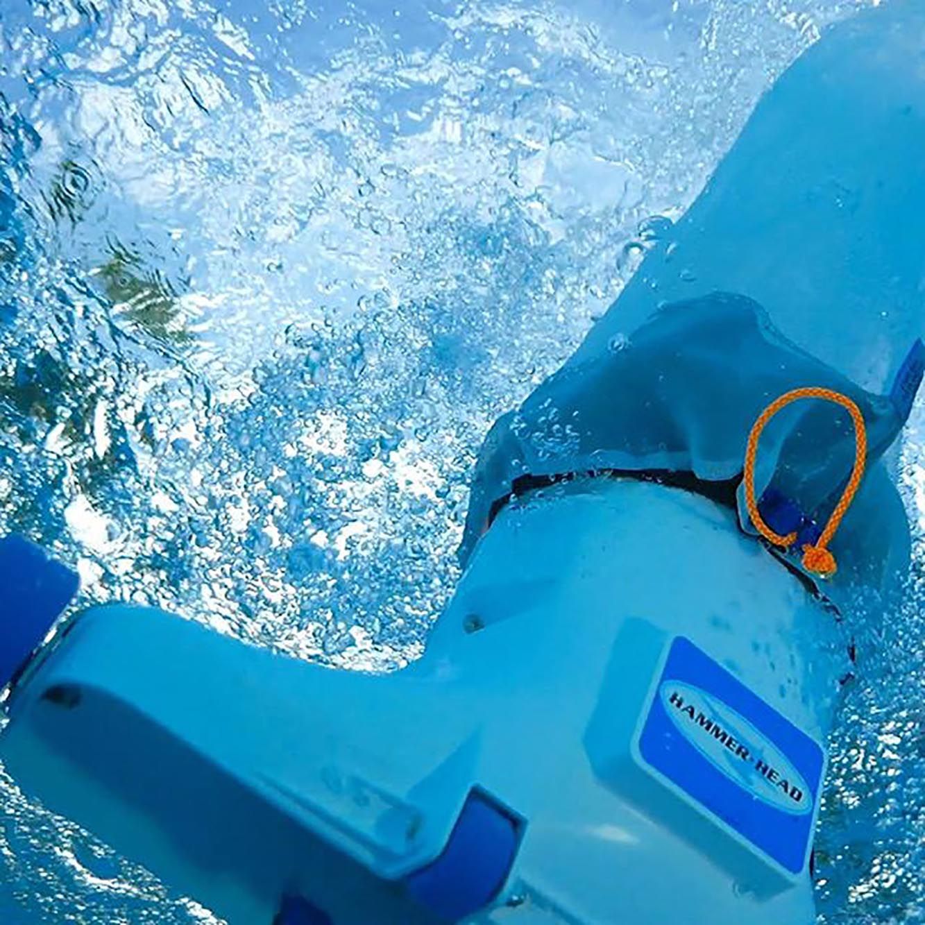 A Hammerhead pool vacuum cleaner submerged in clear blue water, surrounded by air bubbles.
