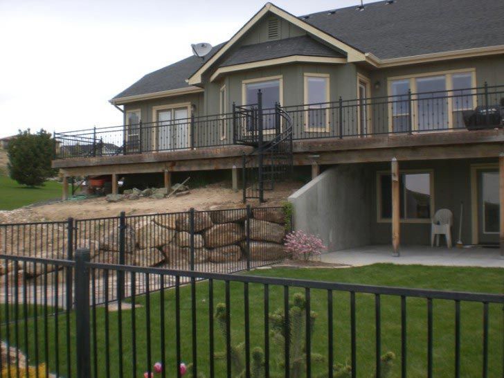 A large house with a deck and a fence around it