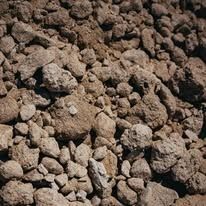 Pile of rough, tan-colored rocks and clumps of dirt.