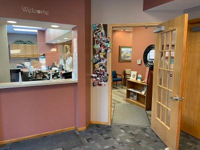 A dental office with a reception desk and a door leading to a waiting room.