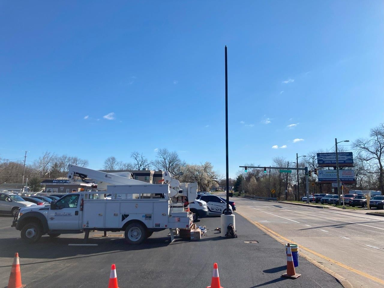 A white truck is parked on the side of the road next to orange cones.