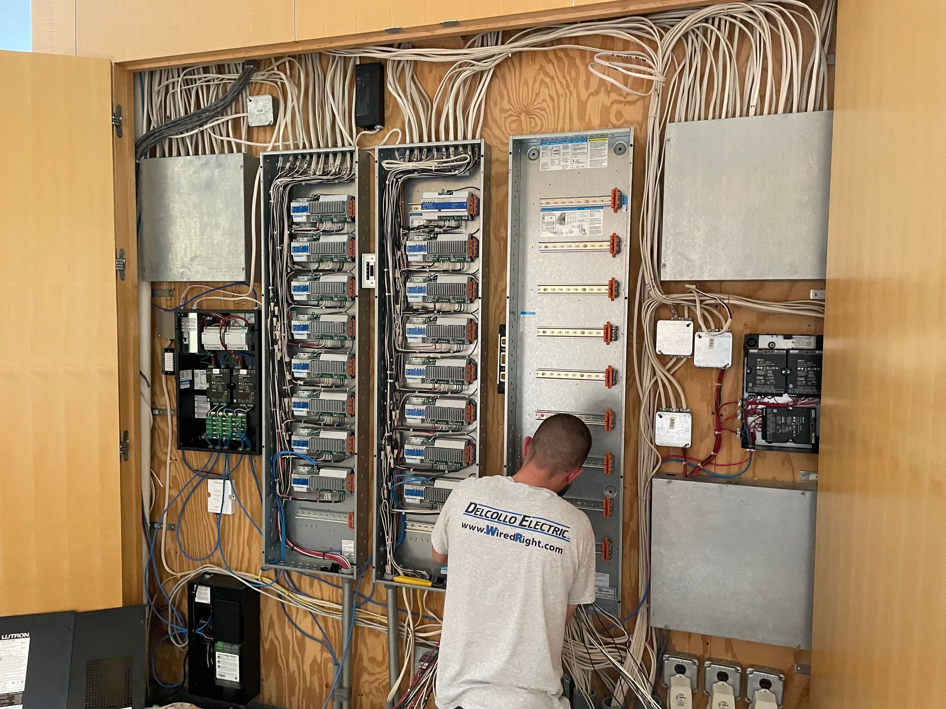 A man is working on a electrical panel in a room.