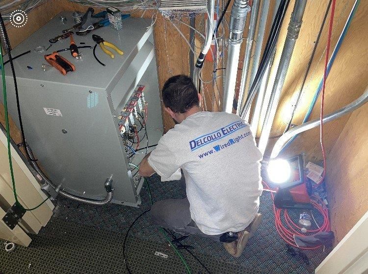 A man is working on an electrical box in a room.