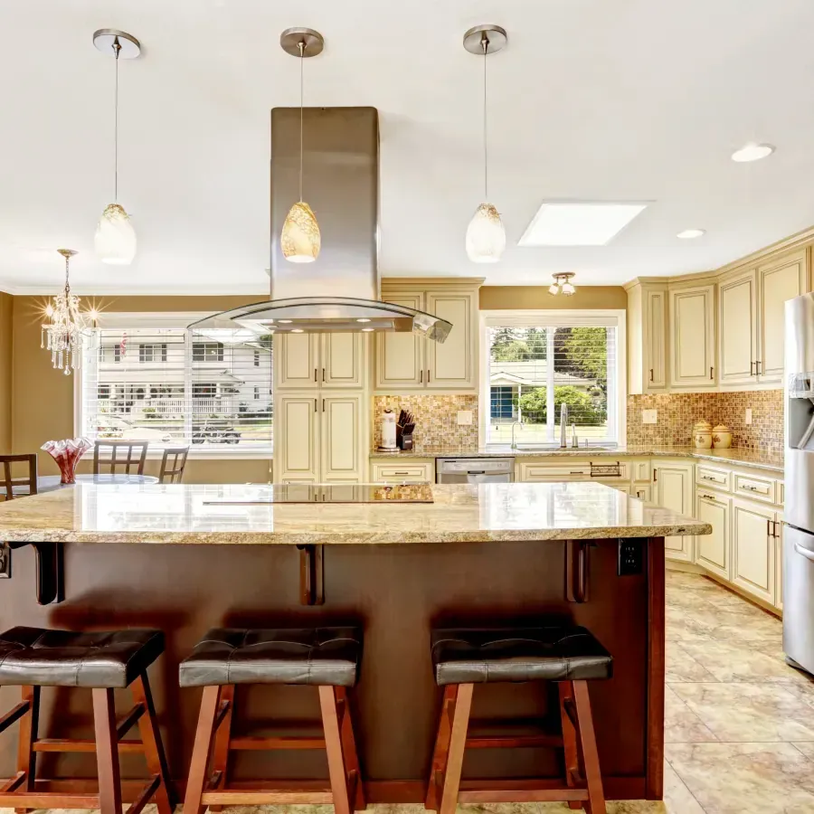 A kitchen with a large island and stools.