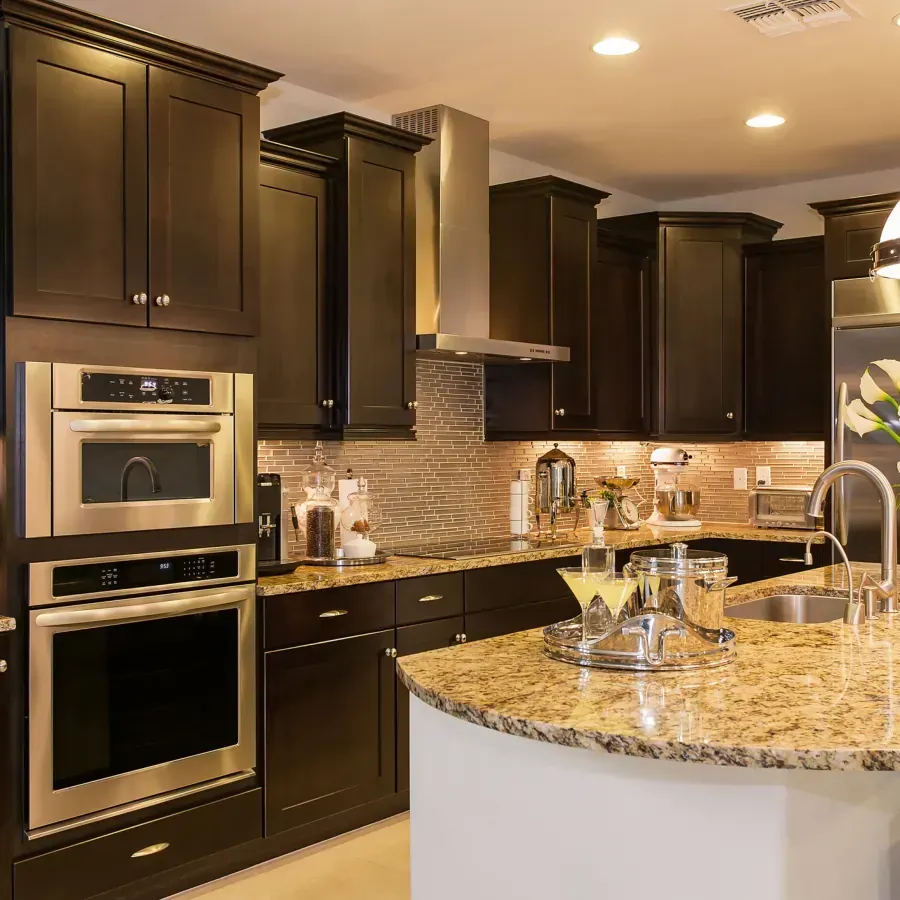A kitchen with black cabinets and stainless steel appliances