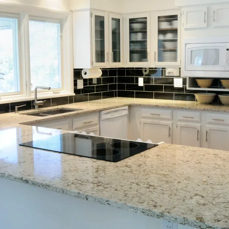 A kitchen with granite counter tops and white cabinets