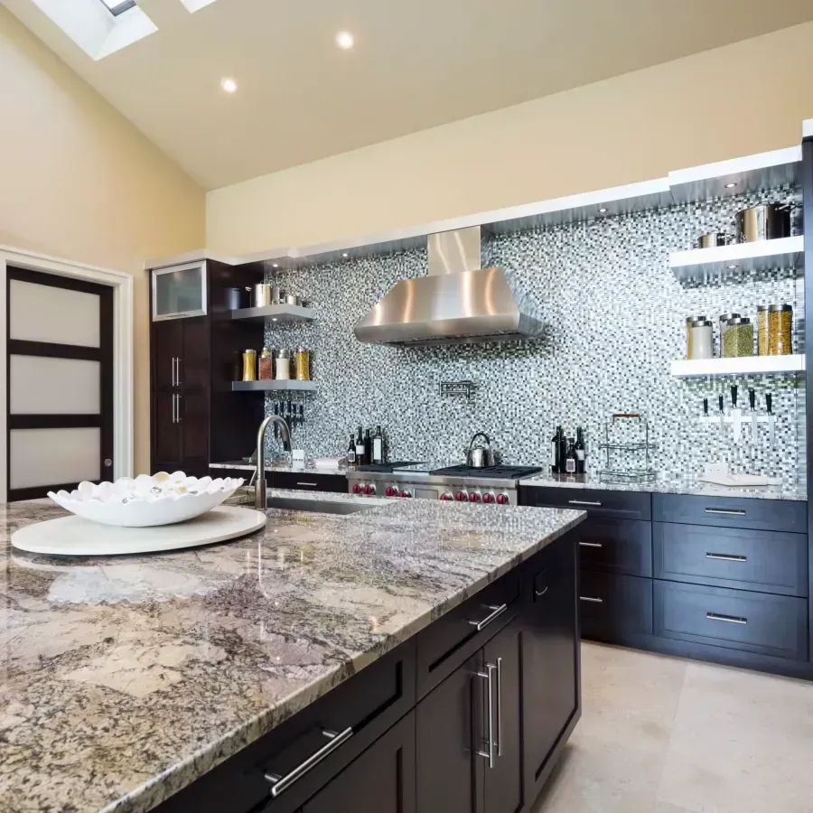 A kitchen with granite counter tops and black cabinets