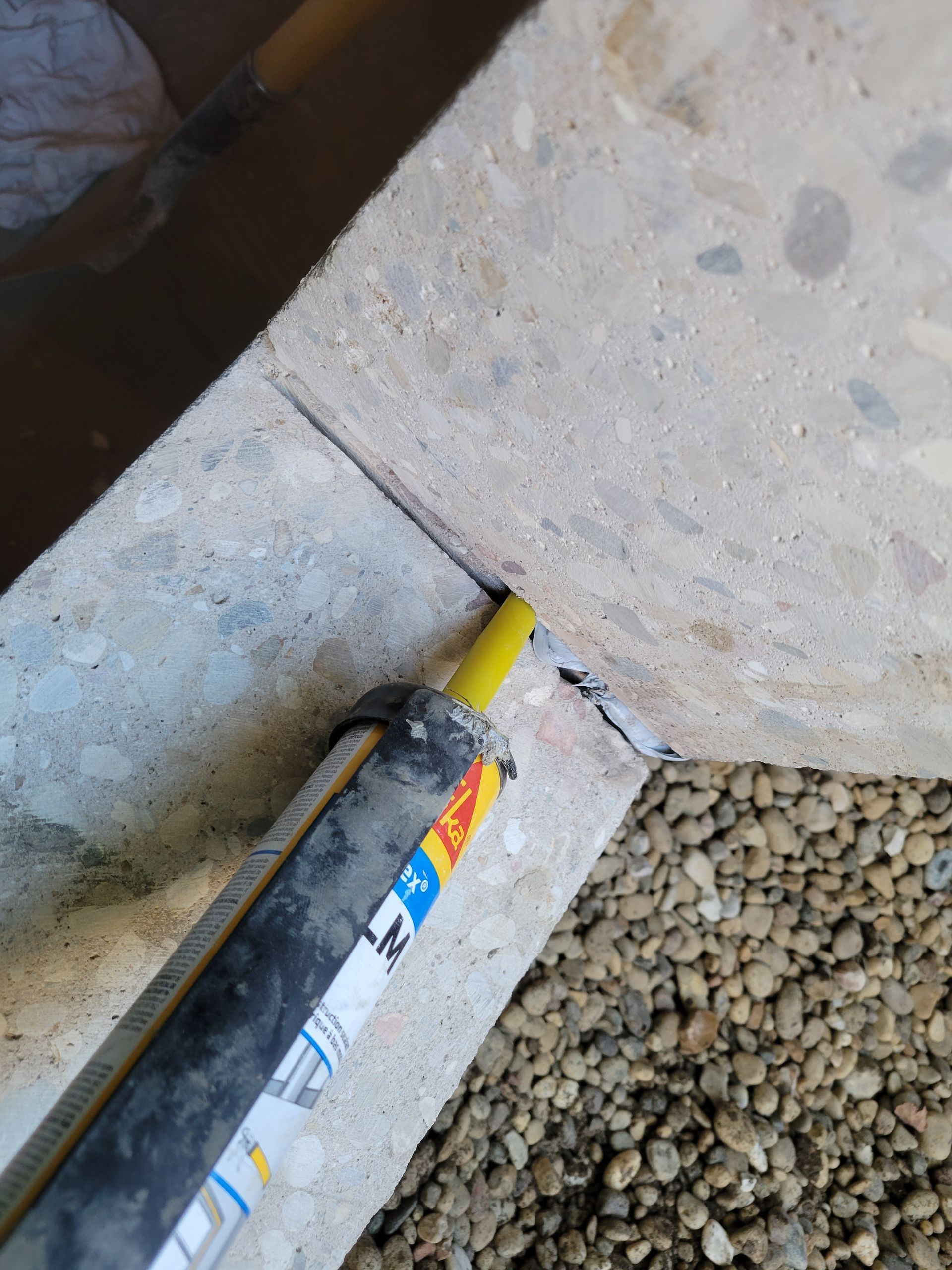 A bottle of sealant is sitting on a concrete surface