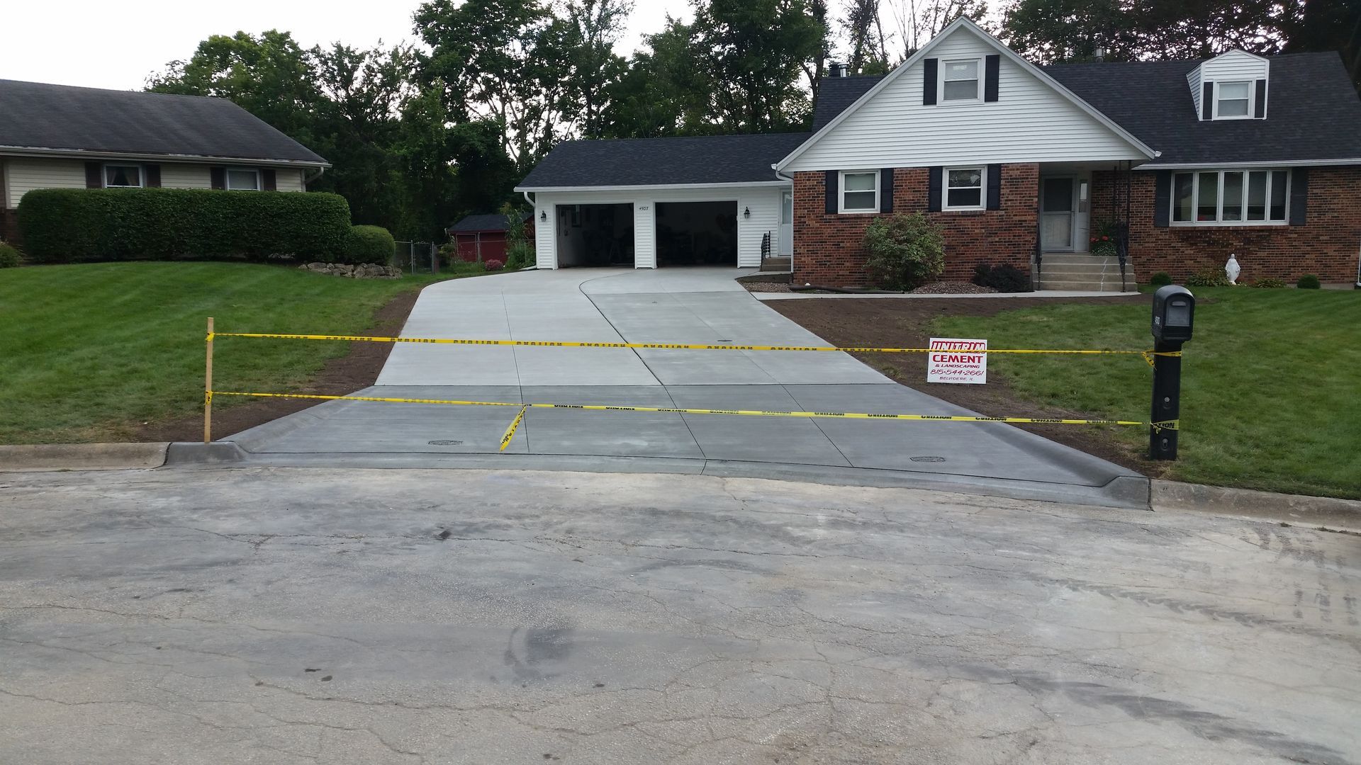 A concrete driveway is being built in front of a house