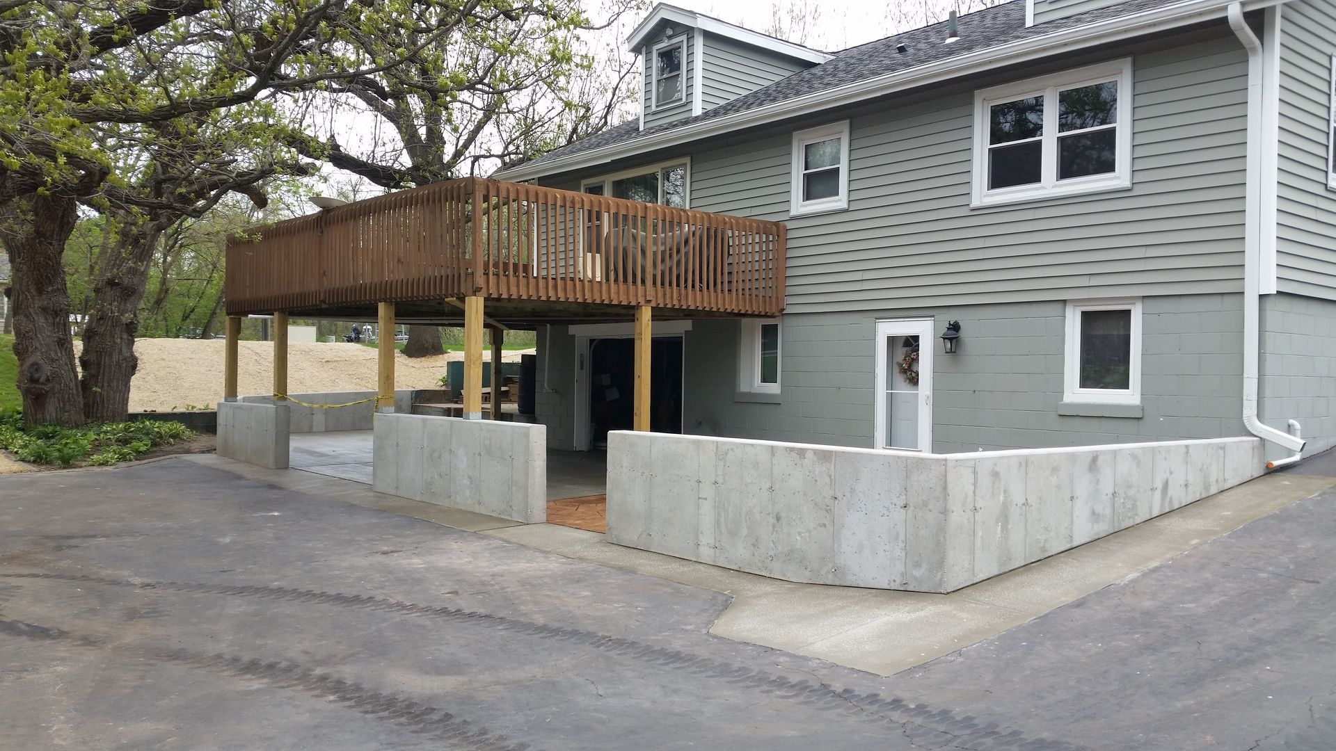 A house with a wooden deck and a concrete wall