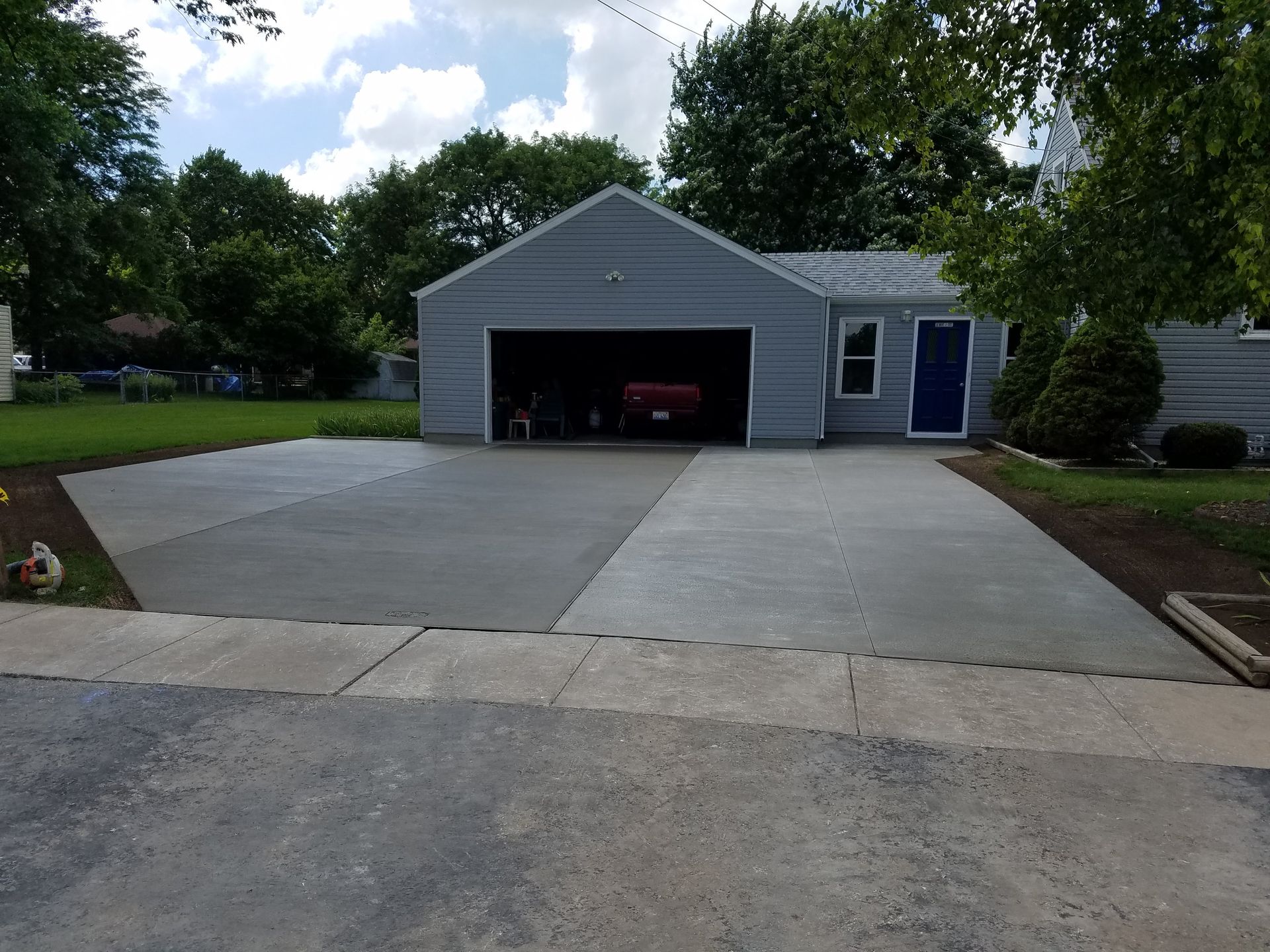 A car is parked in a garage in front of a house