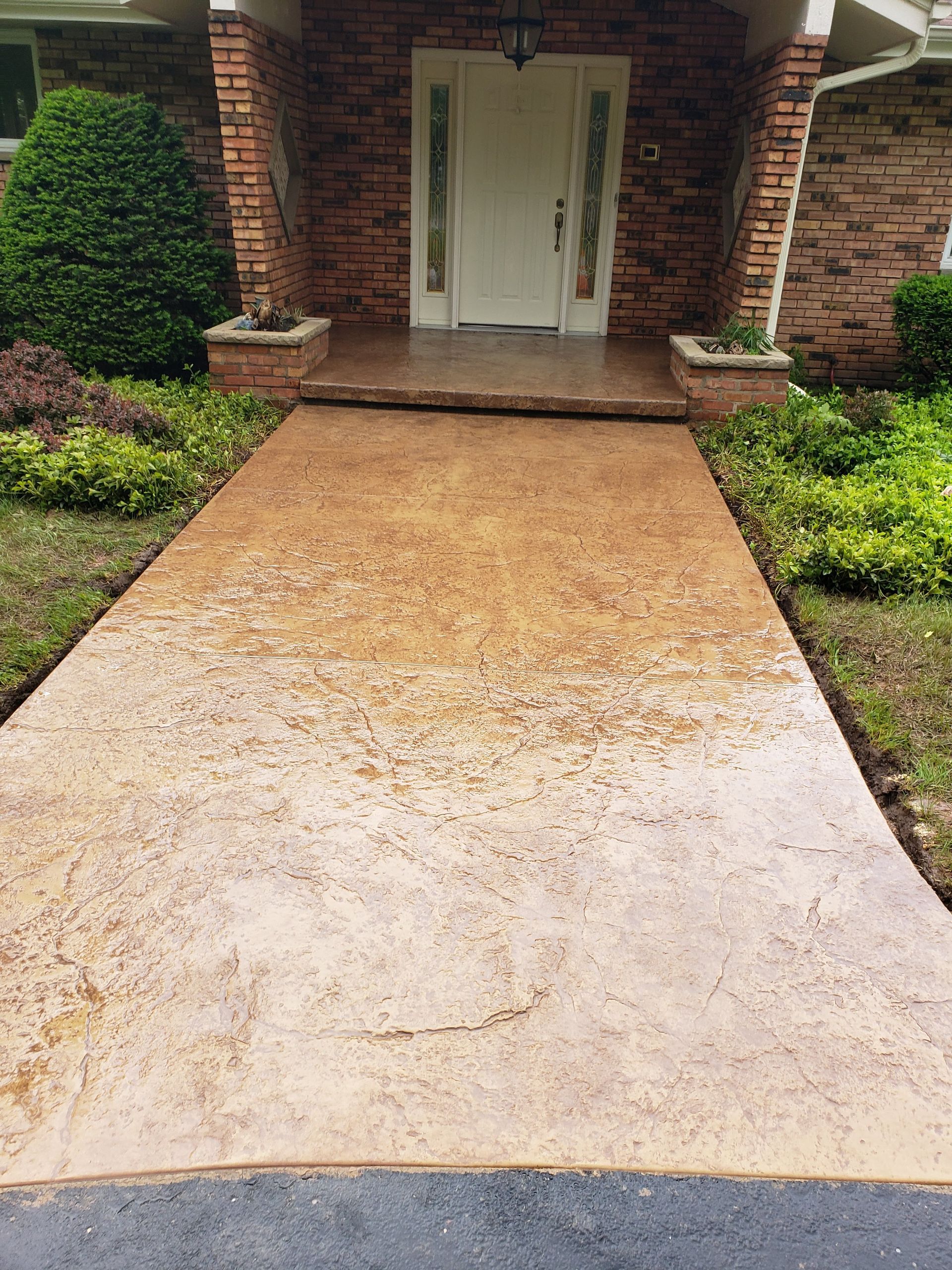 A concrete walkway leading to the front door of a house.