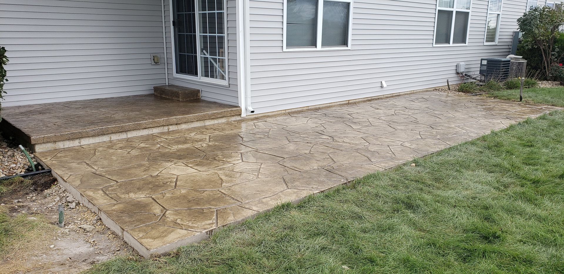 A white house with a concrete walkway in front of it.