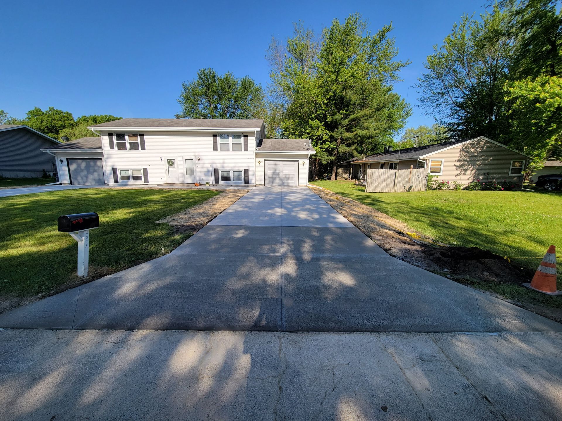A concrete driveway is being built in front of a house.