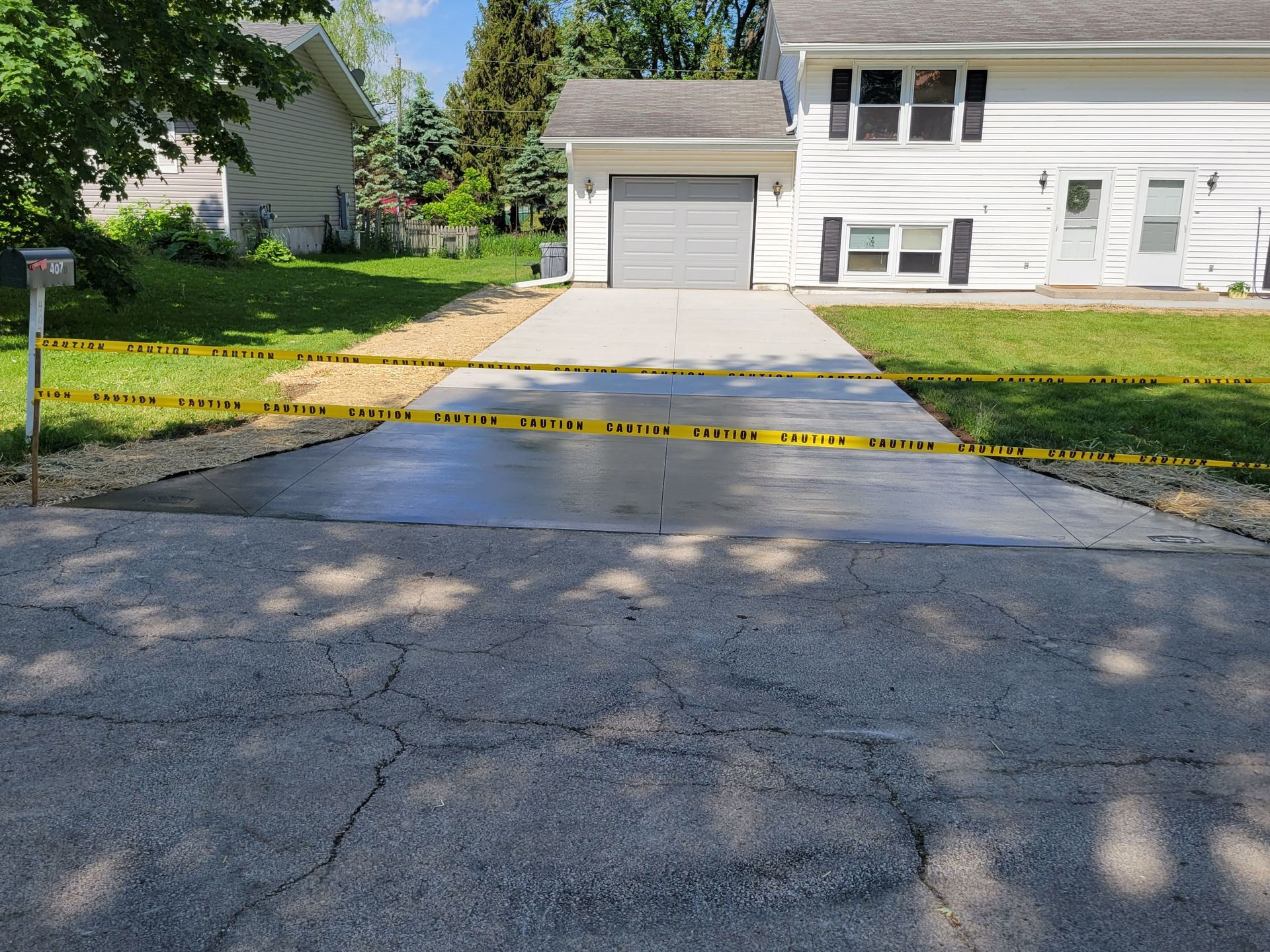 A driveway leading to a house with a yellow tape covering it.
