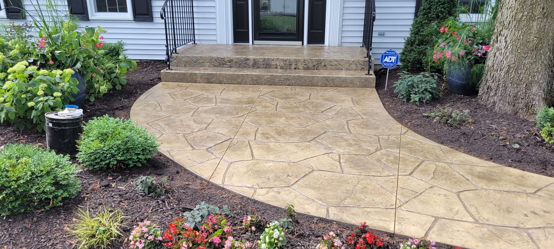 A concrete walkway leading to the front door of a house.