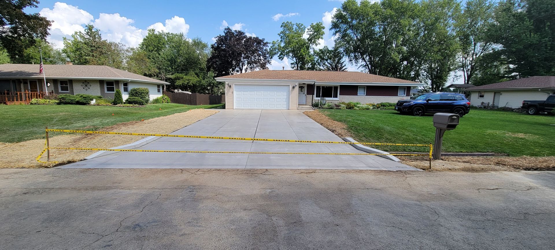 A concrete driveway is being built in front of a house.