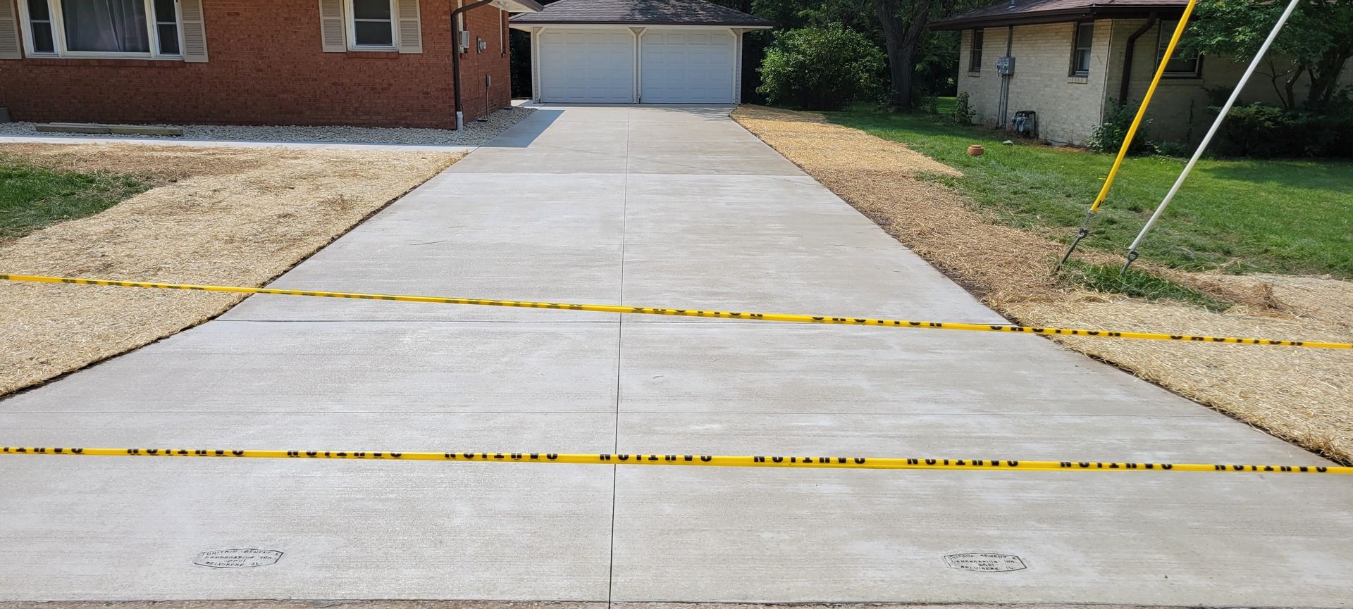 A concrete driveway is being built in front of a house.