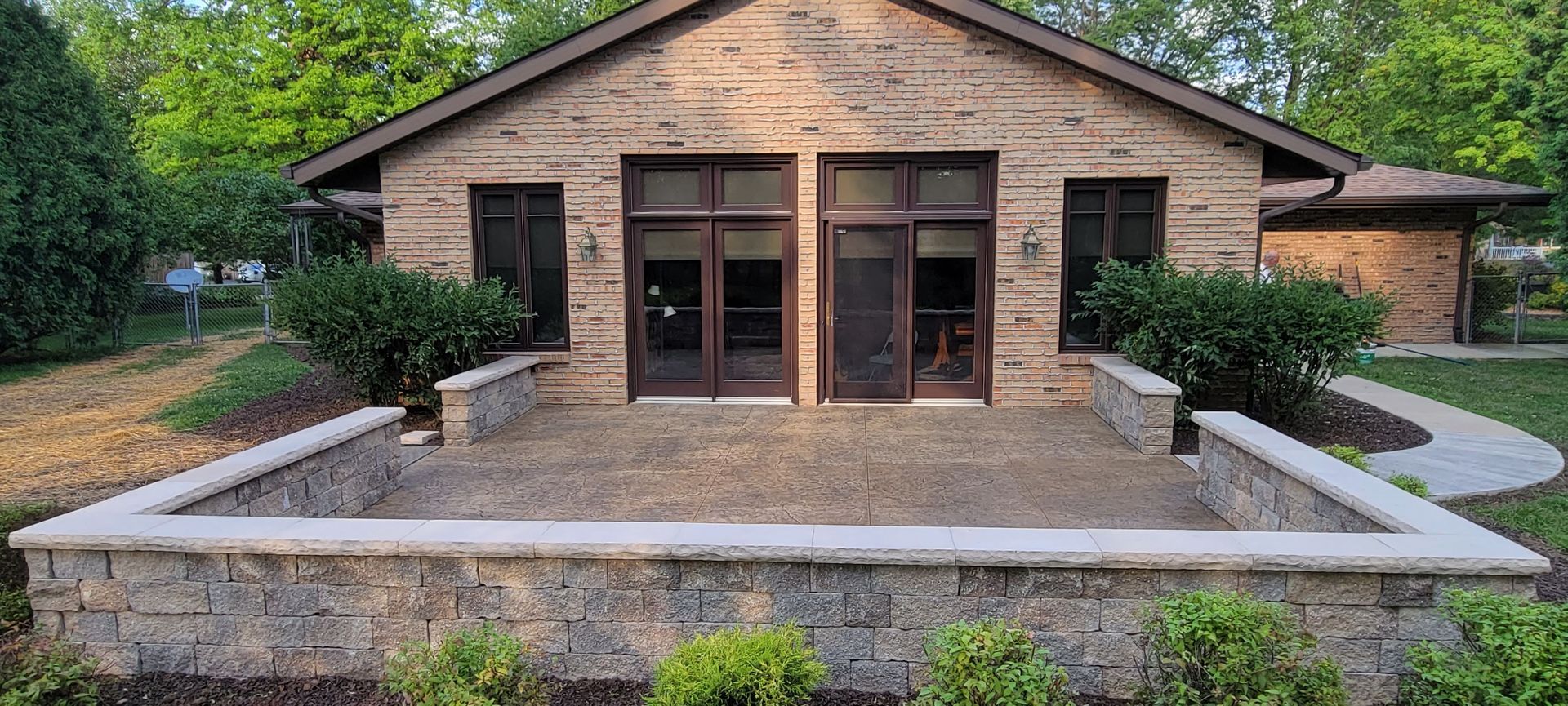 A small brick house with a patio in front of it.