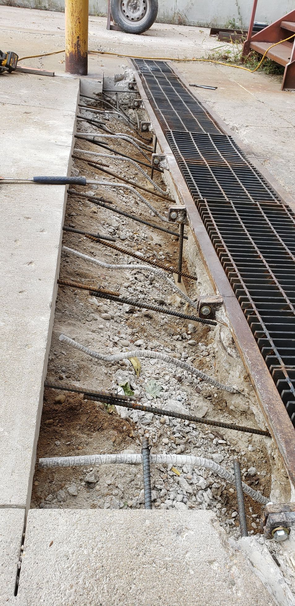 A close-up of a concrete walkway with a metal grate.