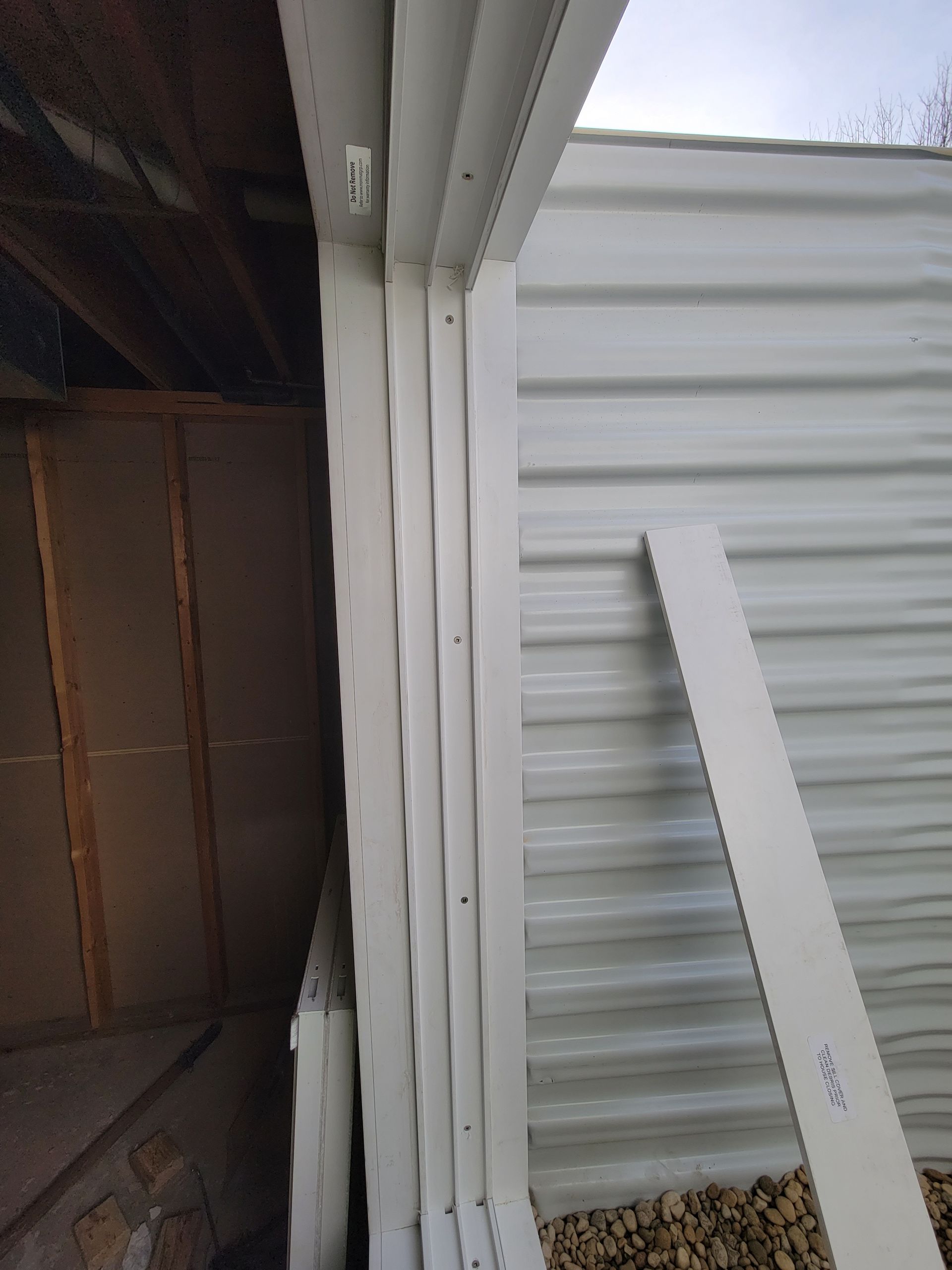 A white building with a sliding glass door is being built.