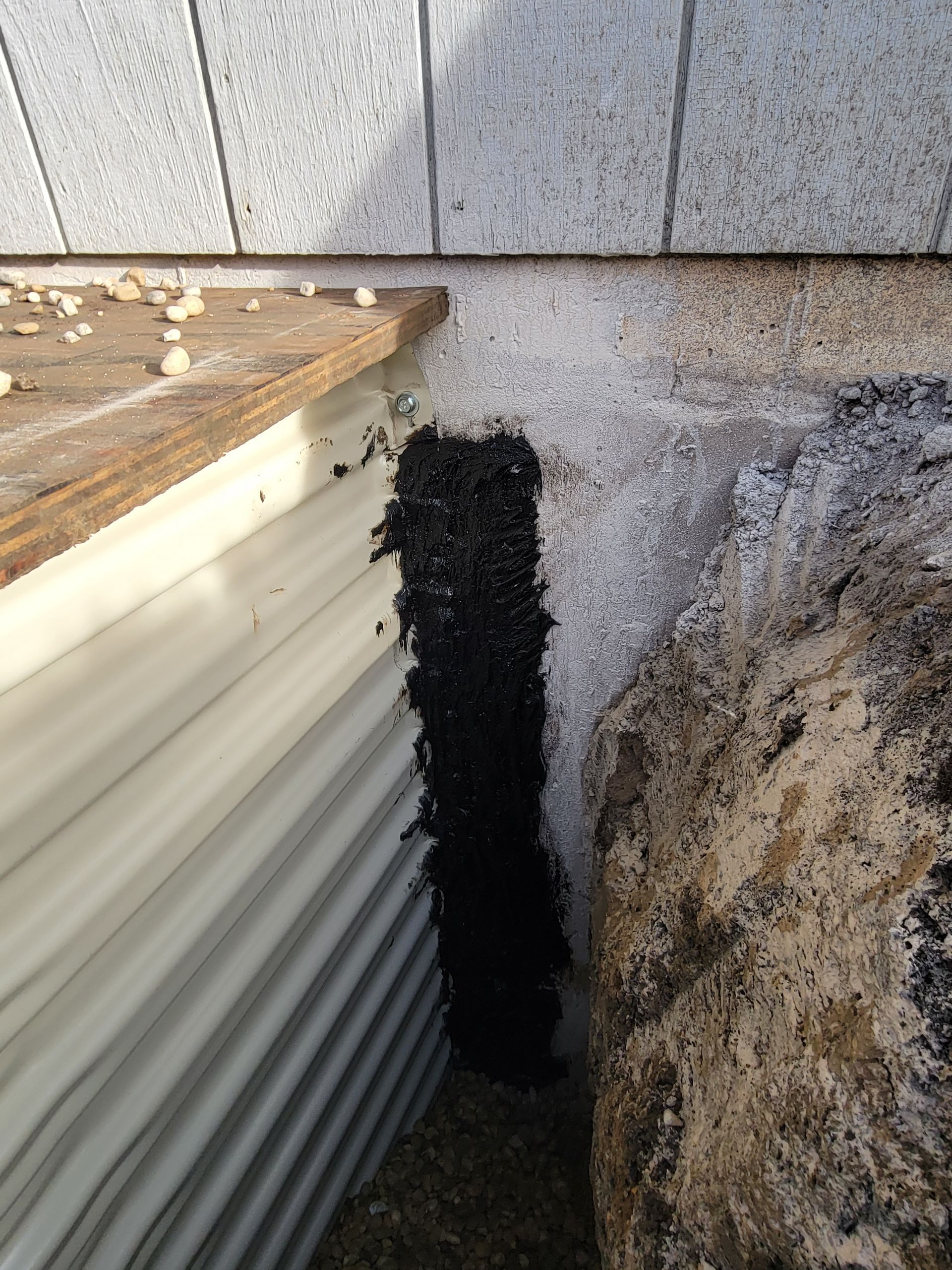 A drainage system is being installed on the side of a building