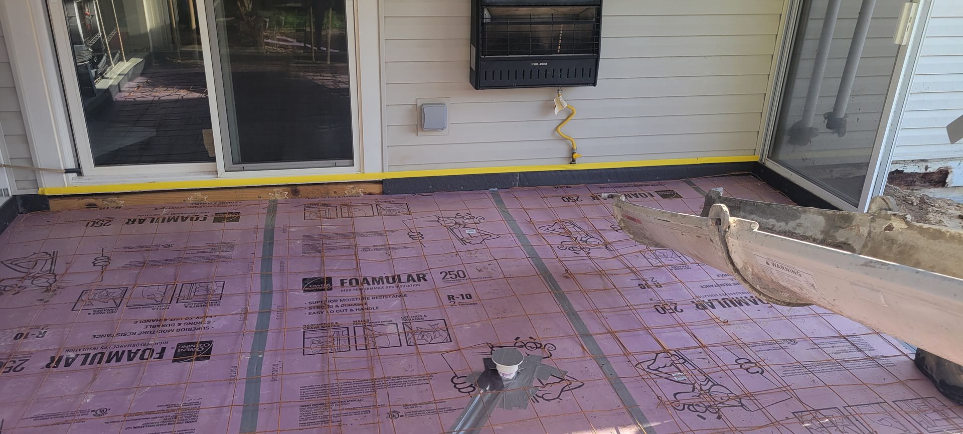 A patio with a sliding glass door is being remodeled.