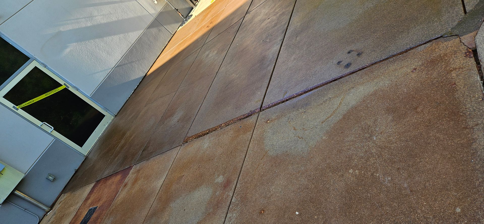 A close up of a concrete sidewalk with a door in the background.