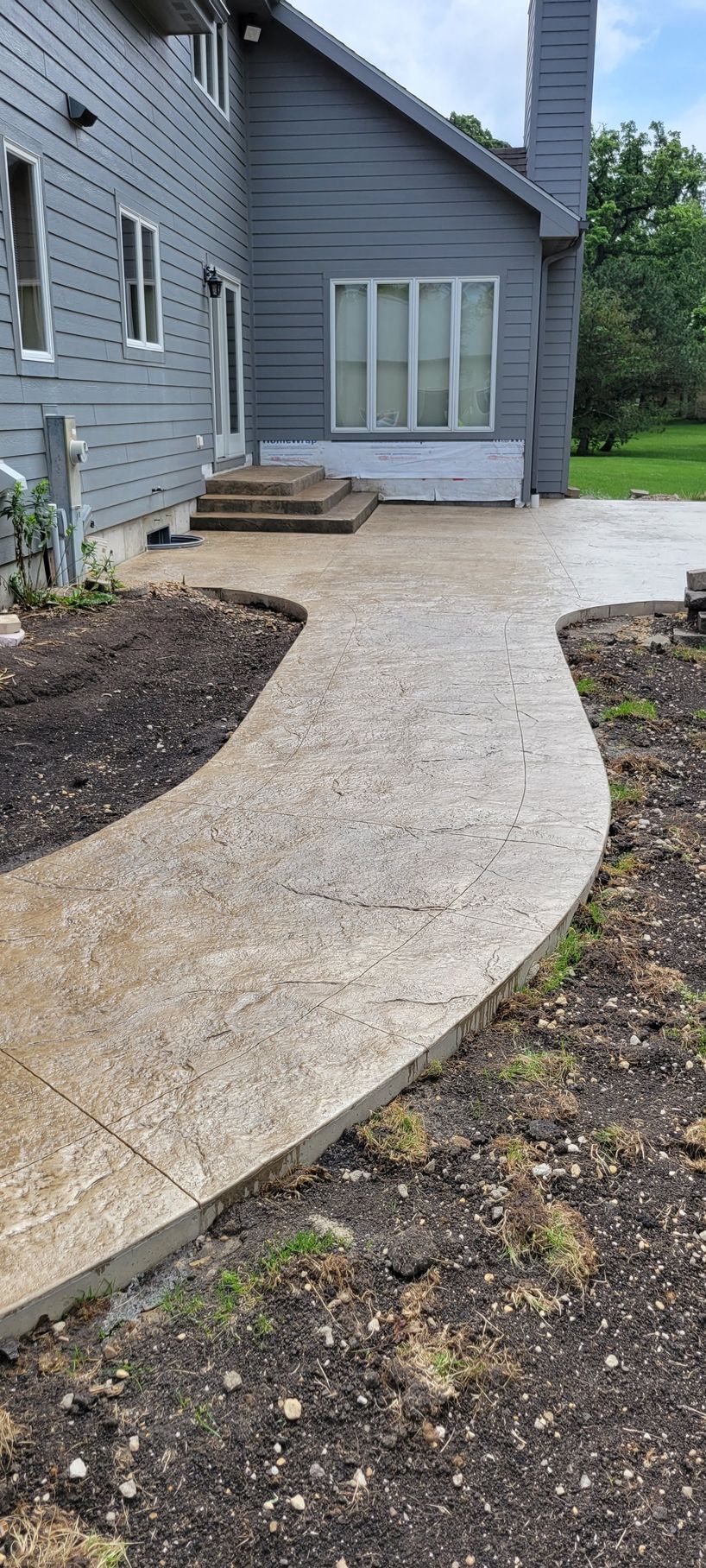 A concrete walkway leading to the back of a house.