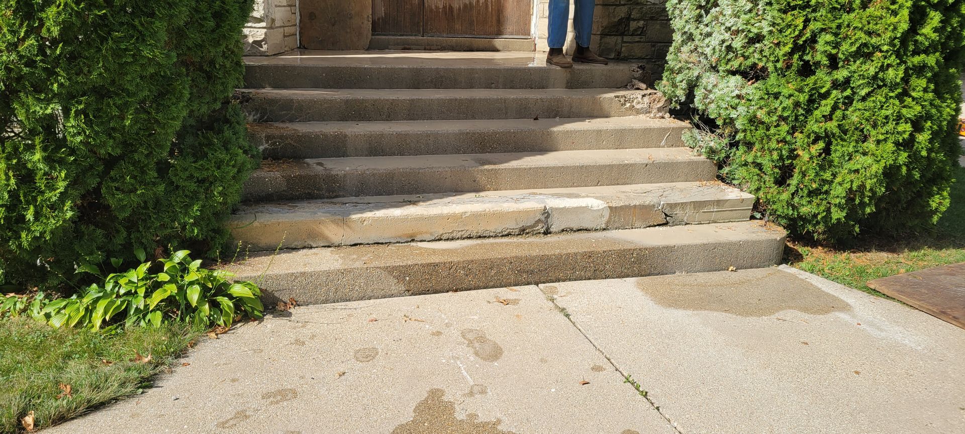 A person is standing on the steps of a house.
