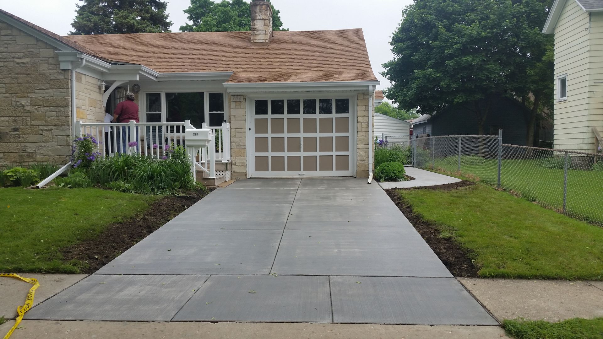 A concrete driveway is being built in front of a house.