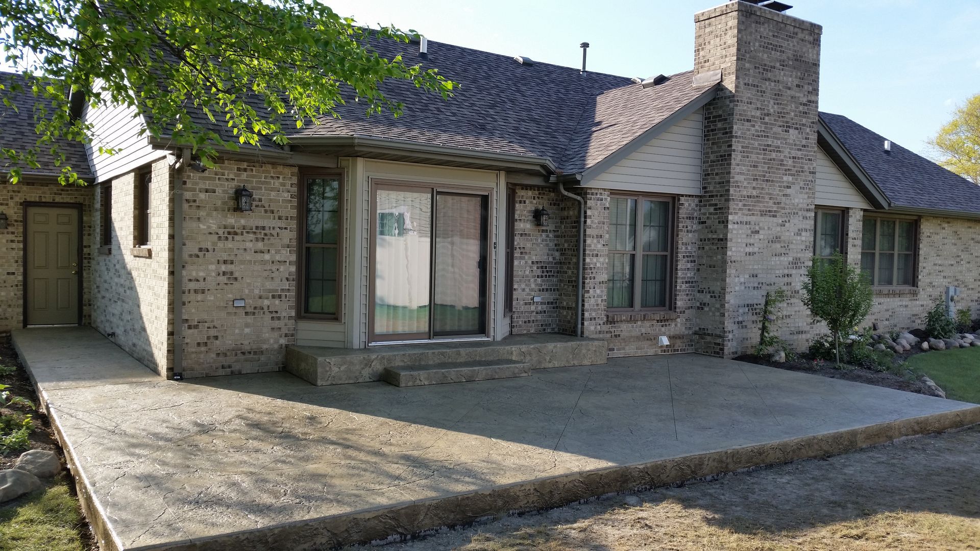 A large brick house with a patio in front of it.