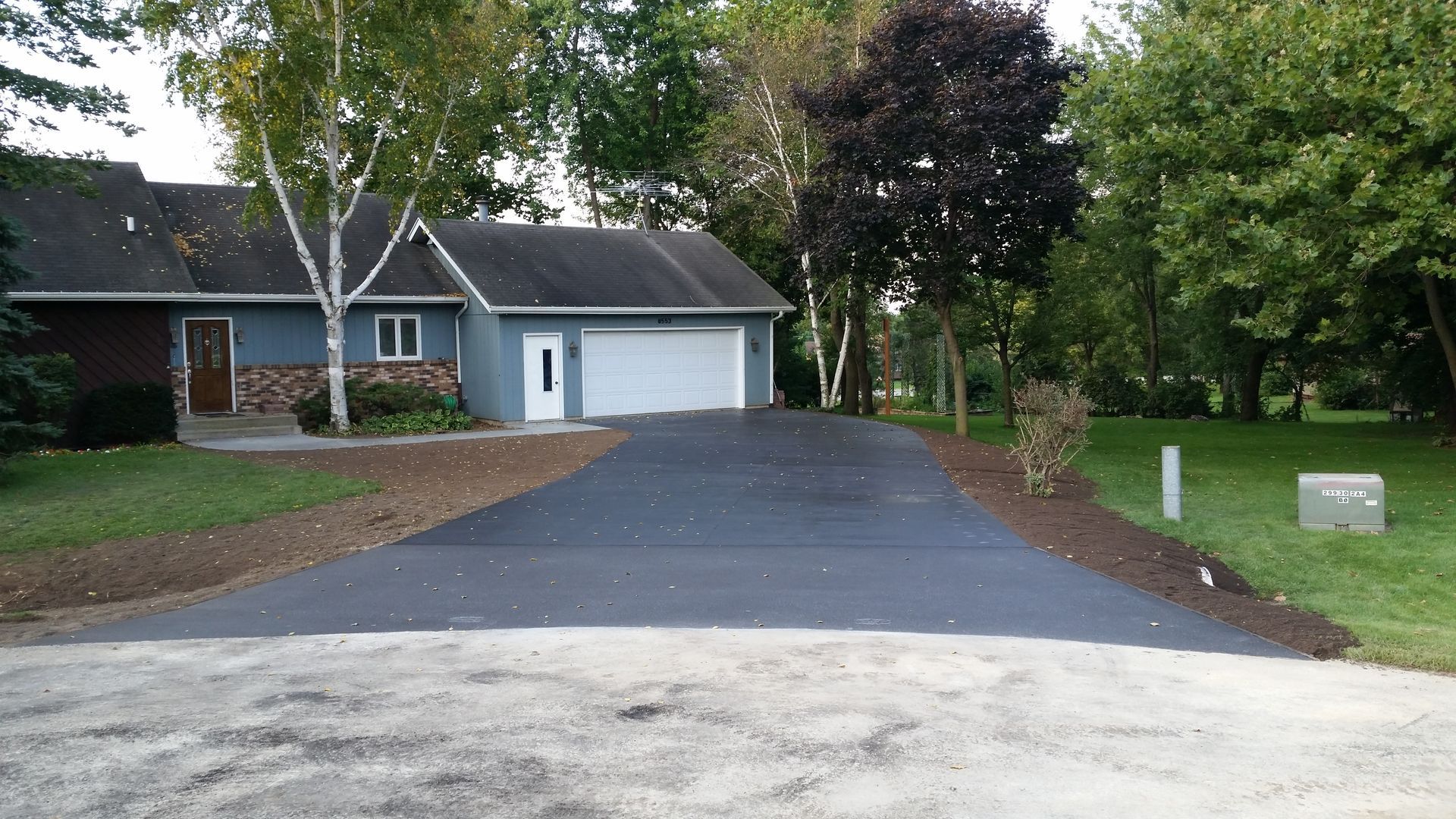 A driveway leading to a house with a garage