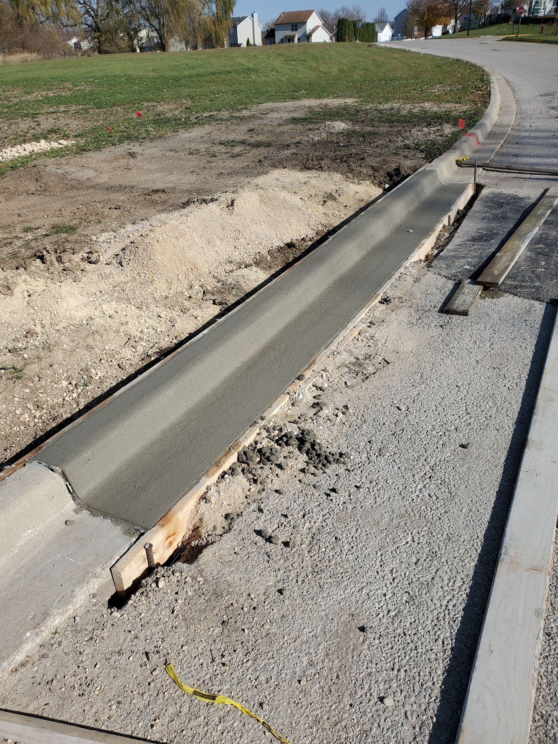 A concrete curb is being built on the side of a road.