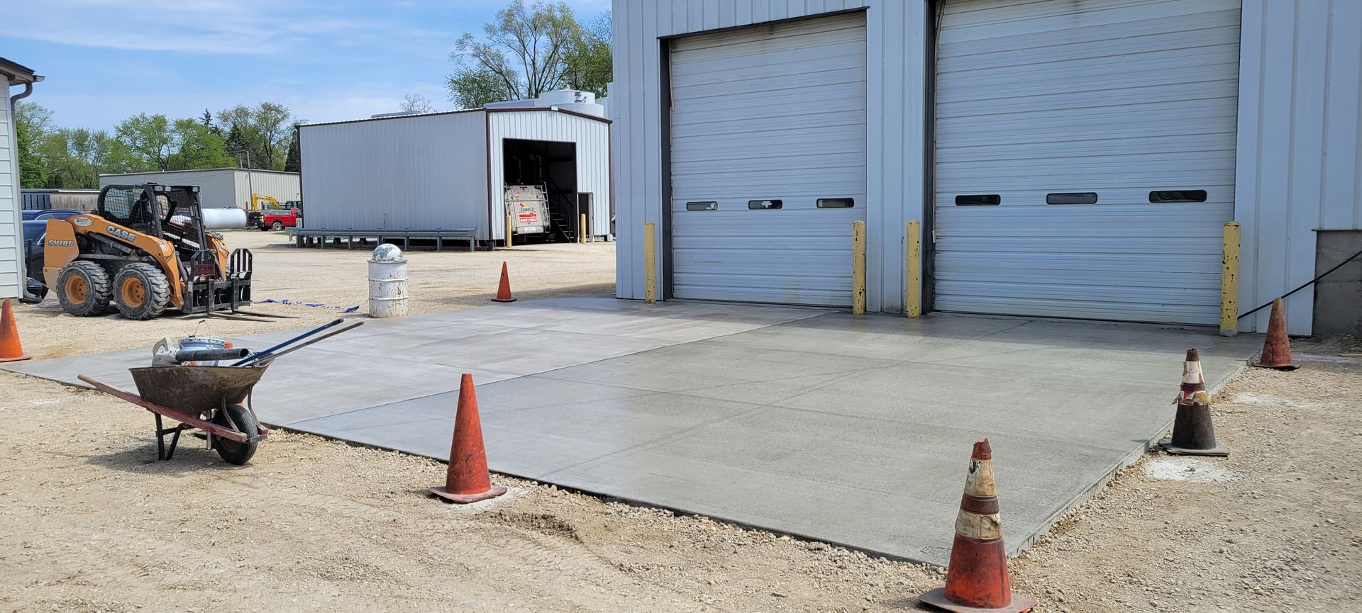 A wheelbarrow is parked in front of a garage.