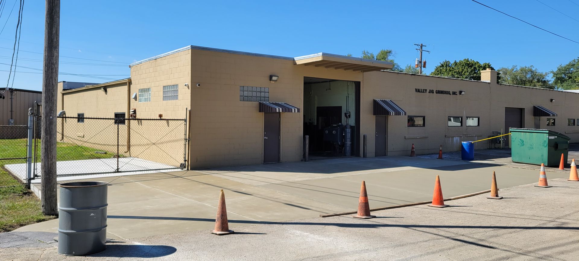 A building with a fence and cones in front of it