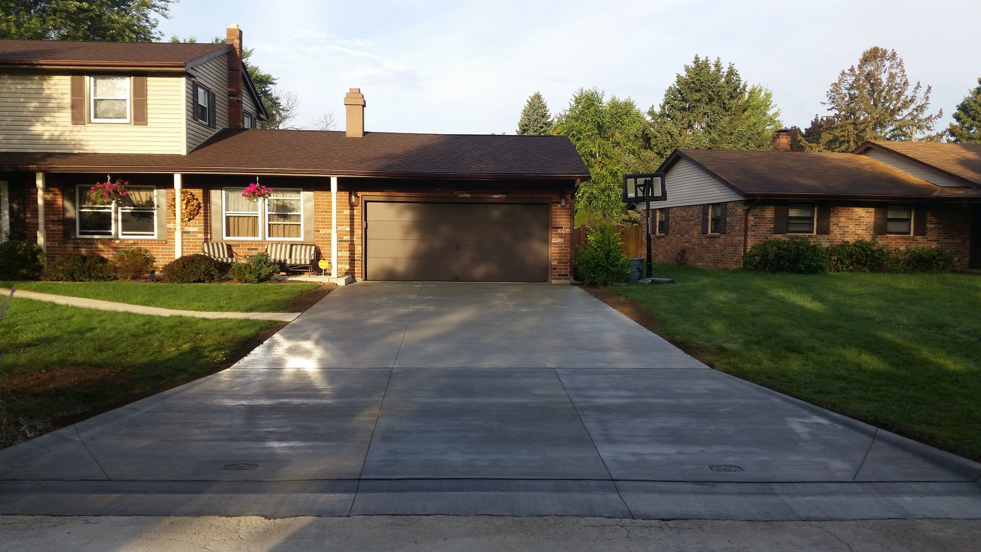 A brick house with a concrete driveway leading to it
